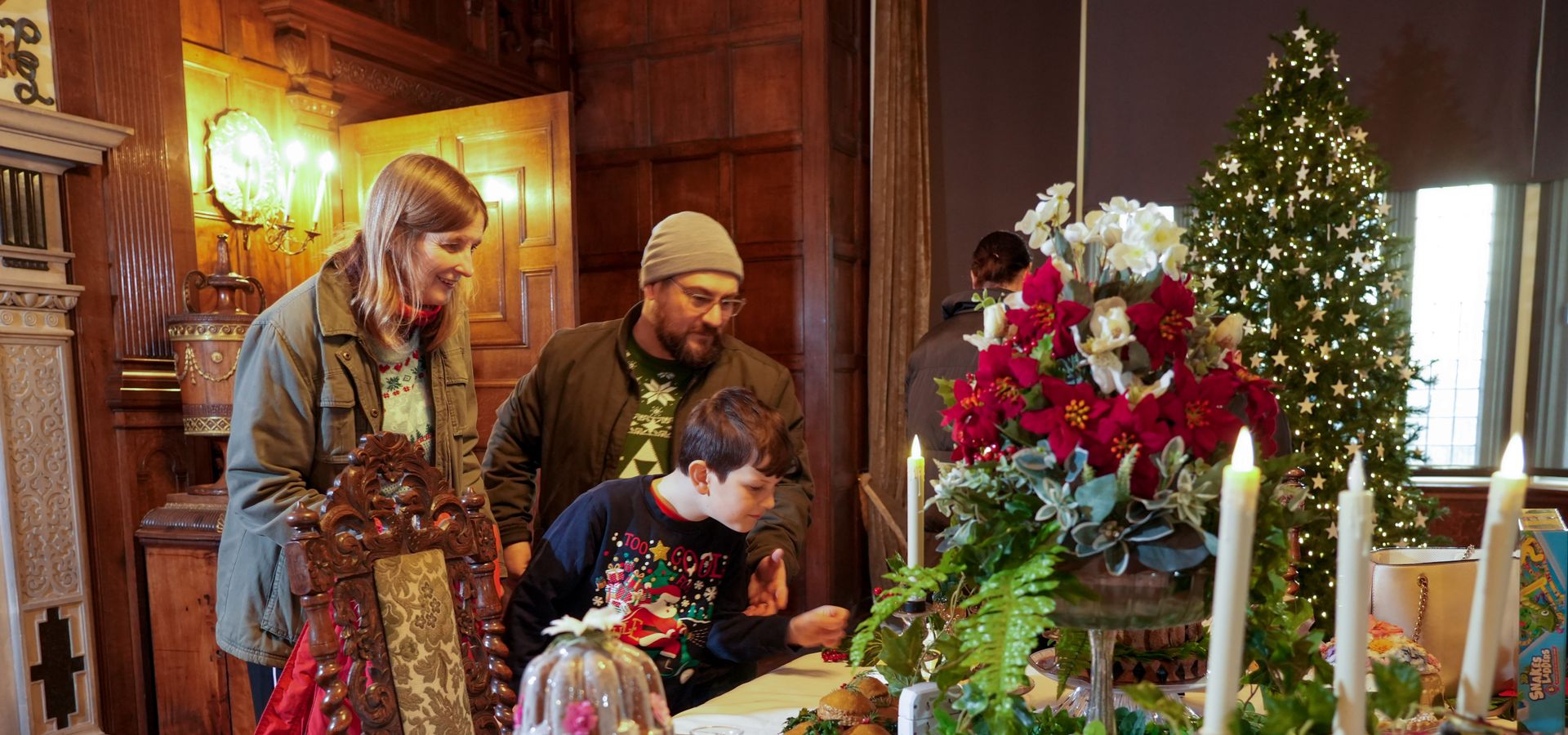 A group of people admiring a festive feast display in the Dining Room of Temple Newsam