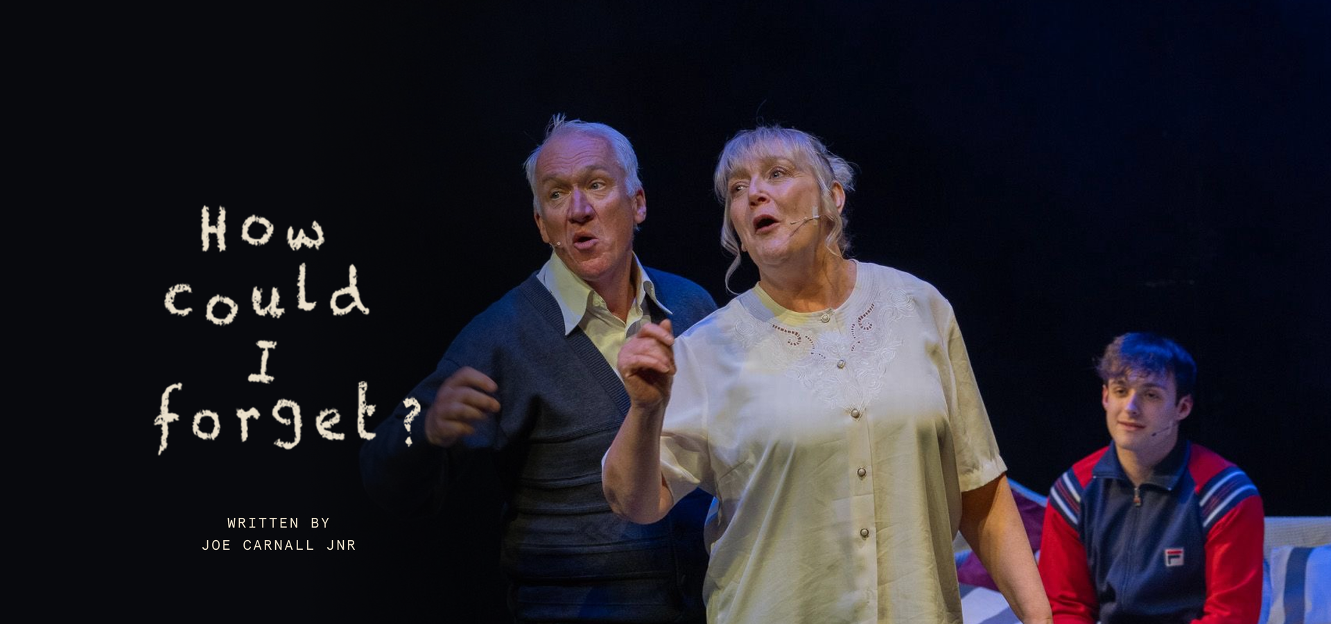 A man and woman sing on a stage, the words 'how could I forget, written by Joe Carnall Jnr' are written to one side.