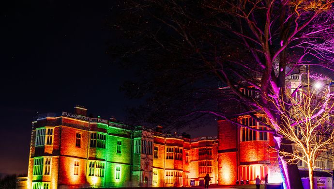 Temple Newsam House illuminated by coloured lights in the evening.