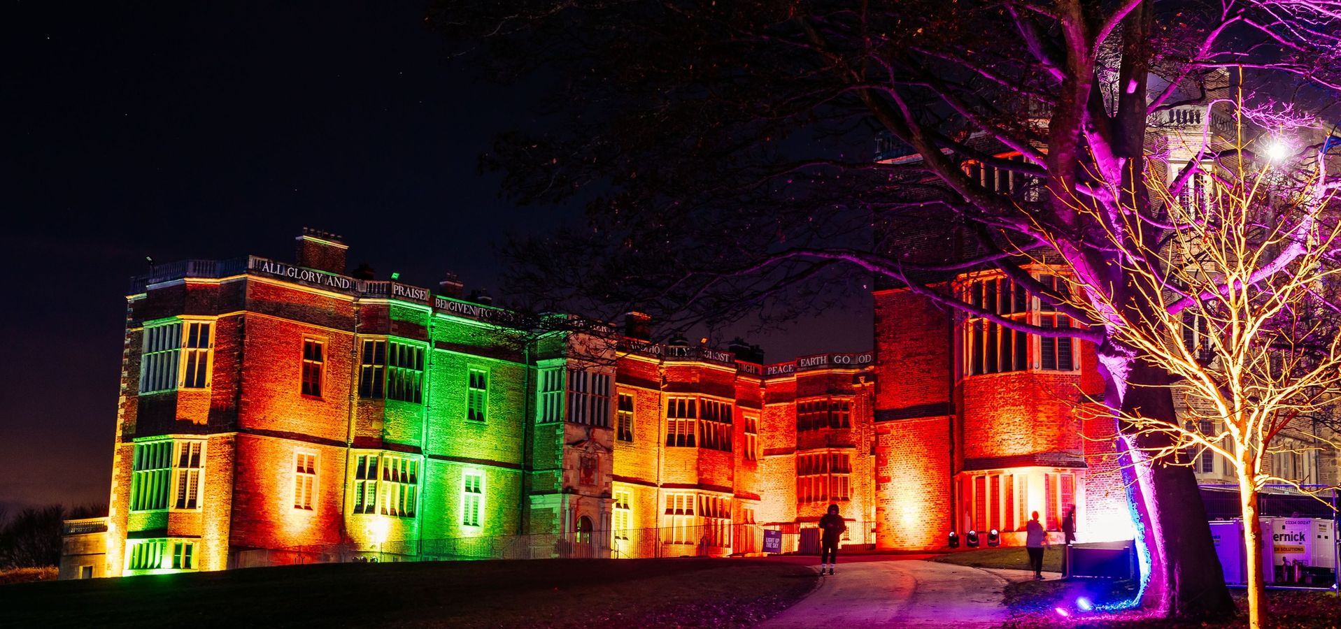 Temple Newsam House illuminated by coloured lights in the evening.
