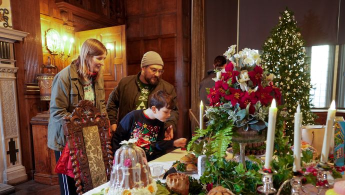 A group of people admiring a festive feast display in the Dining Room of Temple Newsam